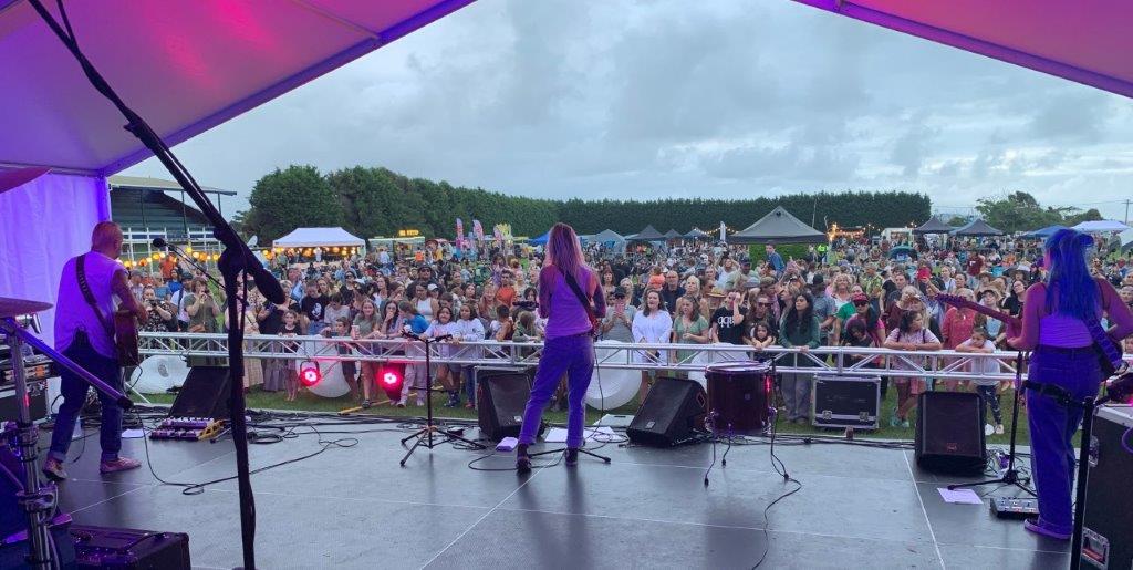 Picture from the back of the stage showing performers on stage and looking out at the crowd at the Opotiki Lantern Festival 2023