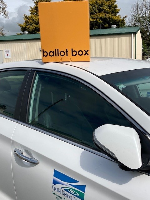 Photo of a Ballot Box on top of car