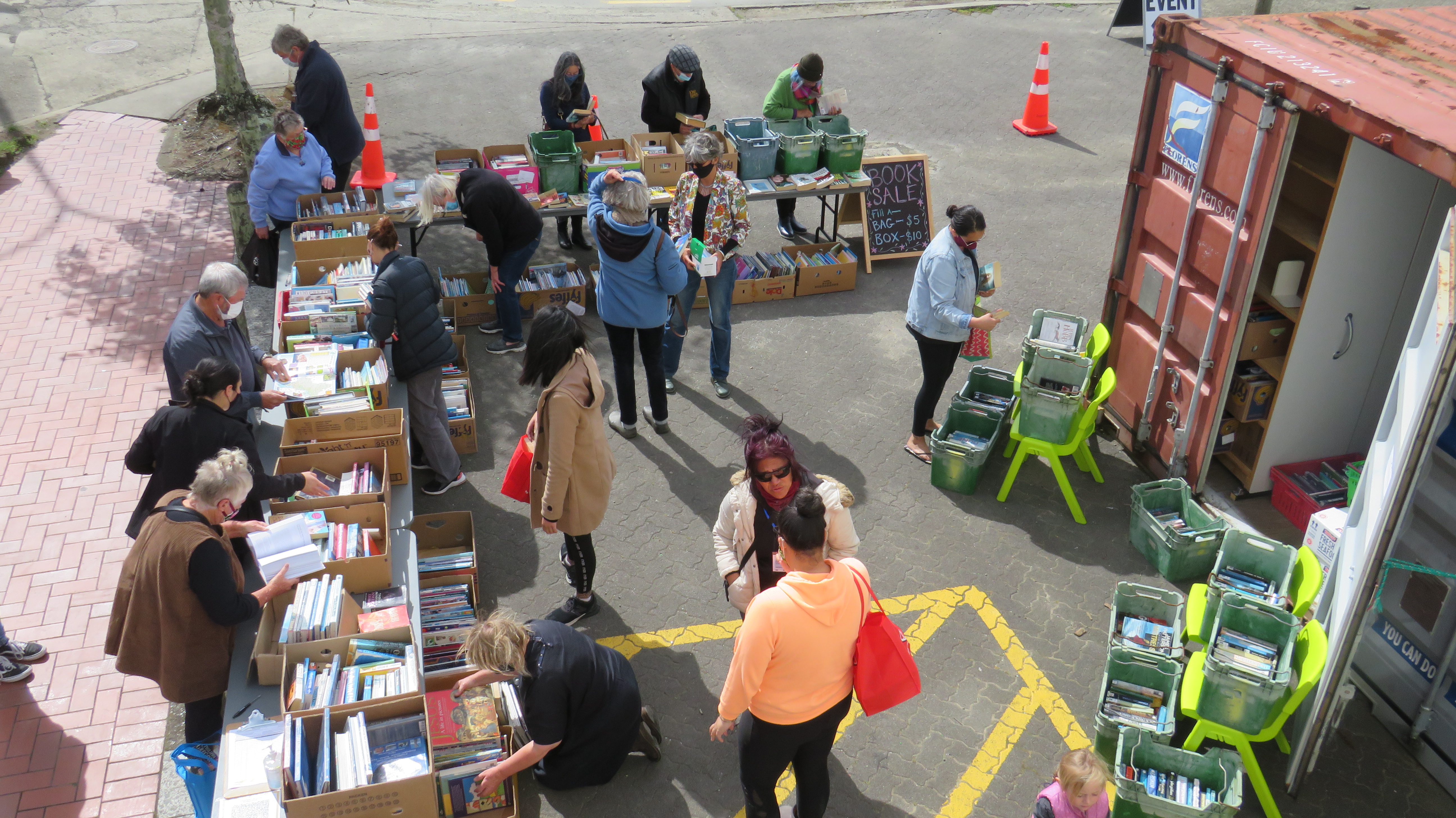 Photo of people looking at books at the library book sale in the Moody Place carpark
