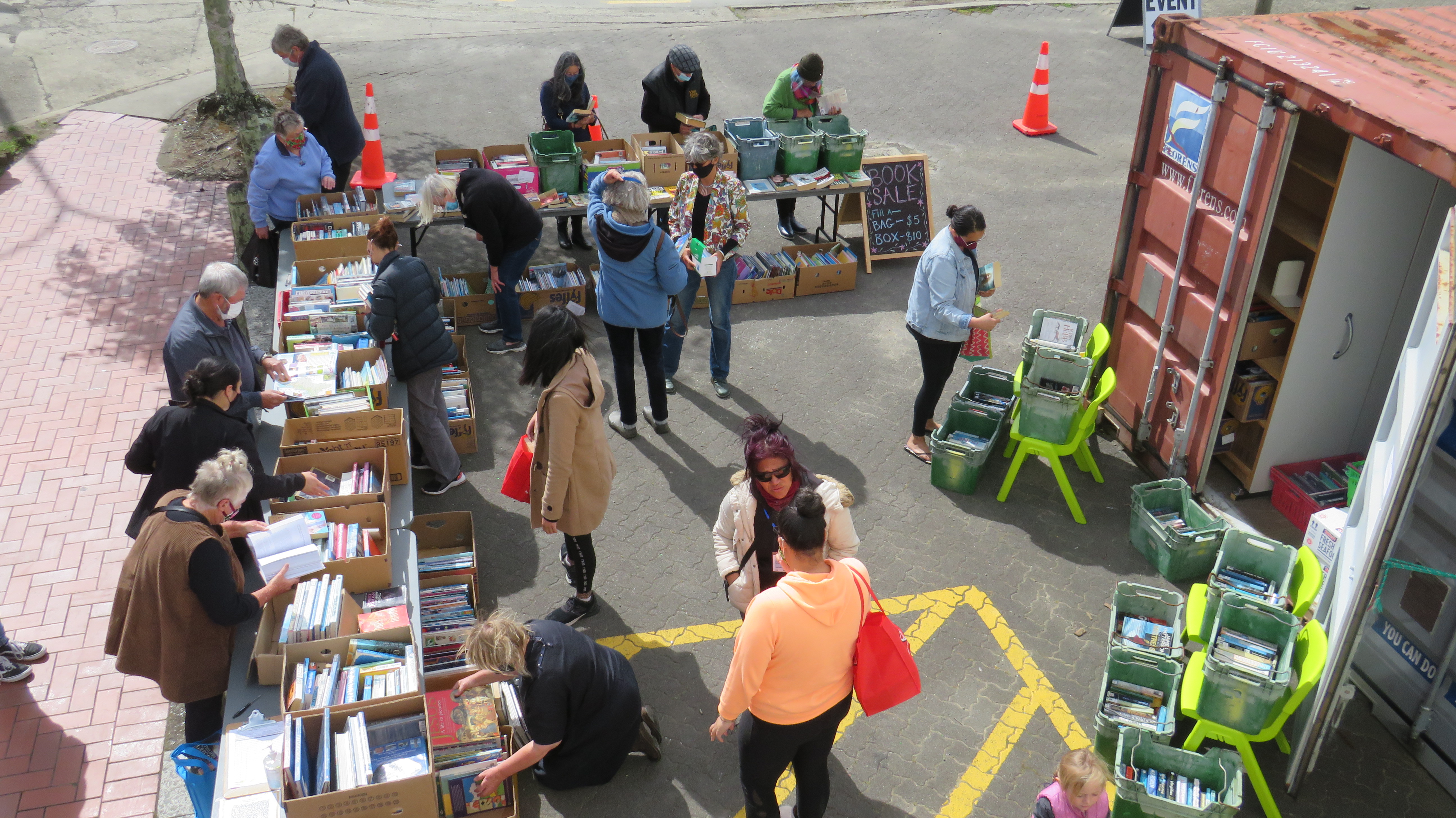Photo of people looking at books at the library book sale in the Moody Place carpark